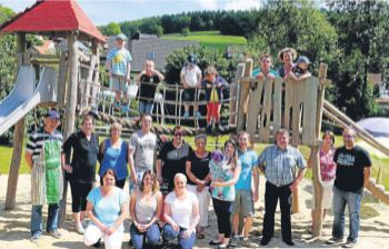 Freuten sich über den neu gestalteten Spielplatz in Kirchhof: Die Elterninitiative Spielplatz Wiesengrund mit Vertretern der Stadt. Rechts Felix Peters, der allen vorführte, wie schön die Seilbahn funktioniert. Fotos: Hirchenhain